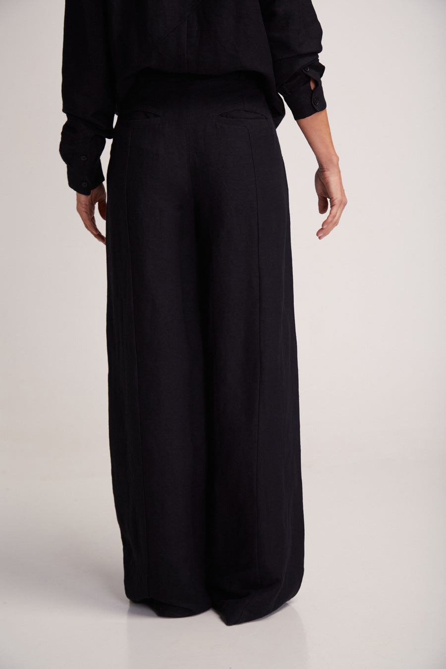 Frau in elegantem schwarzen Outfit von hinten