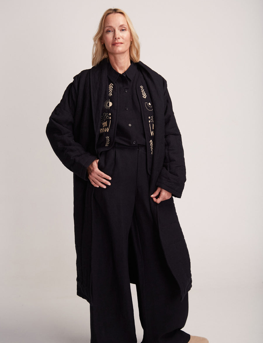 Frau in bestickter schwarzer Jacke und Hose