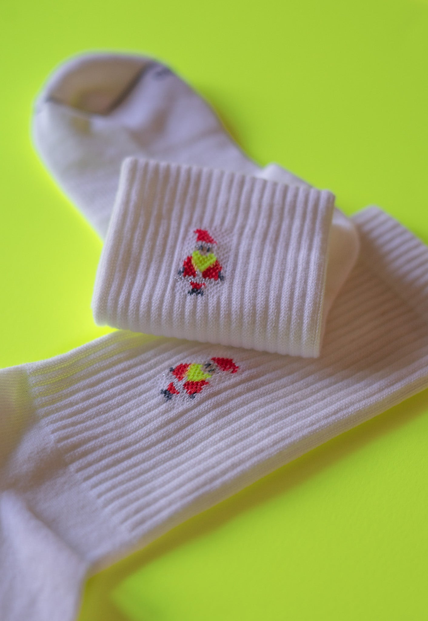 Weiße Socken mit rotem Pizzamotiv auf gelbem Hintergrund