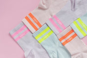 Bunte Socken auf rosa Hintergrund.