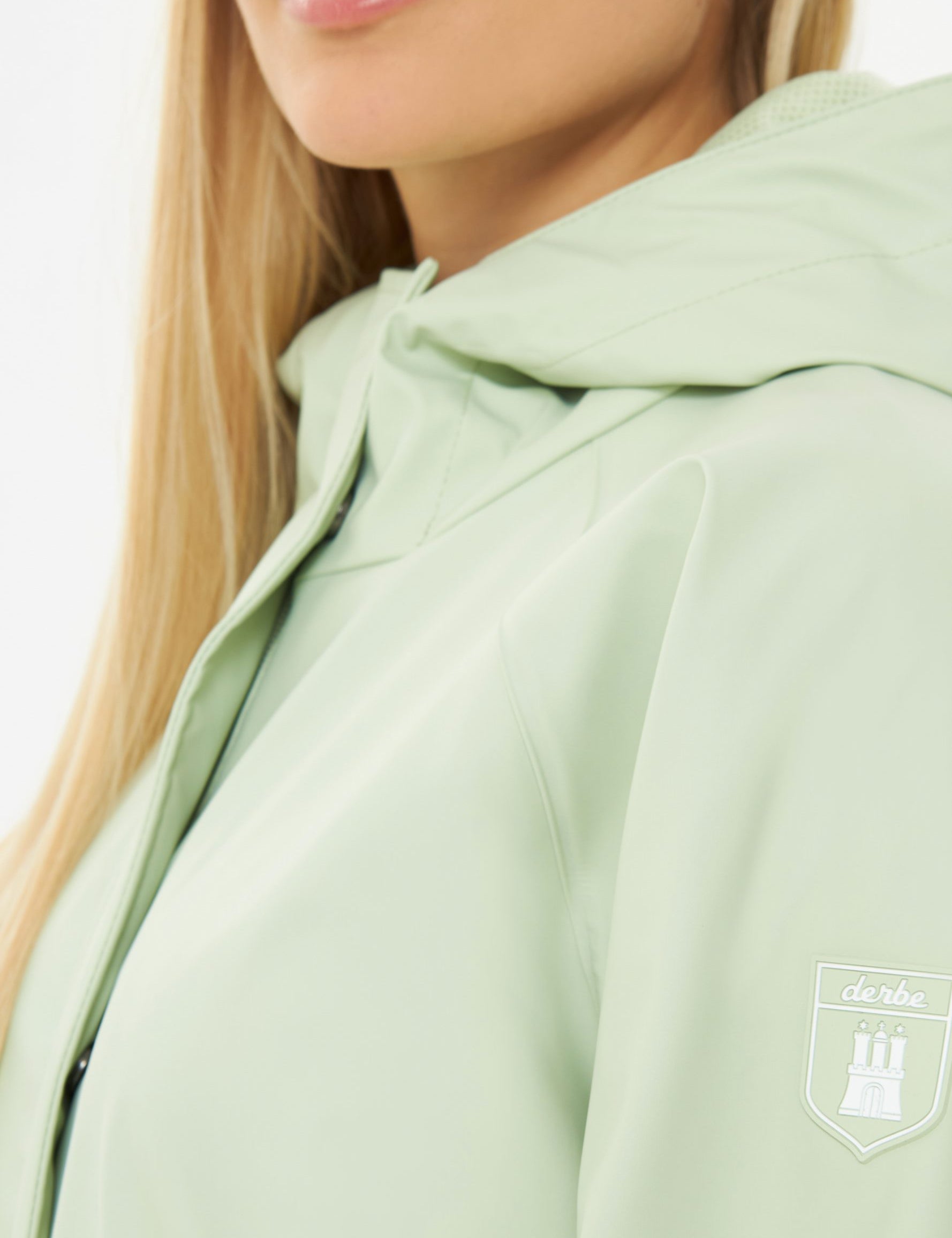 Frau in hellgrüner Regenjacke, Nahaufnahme