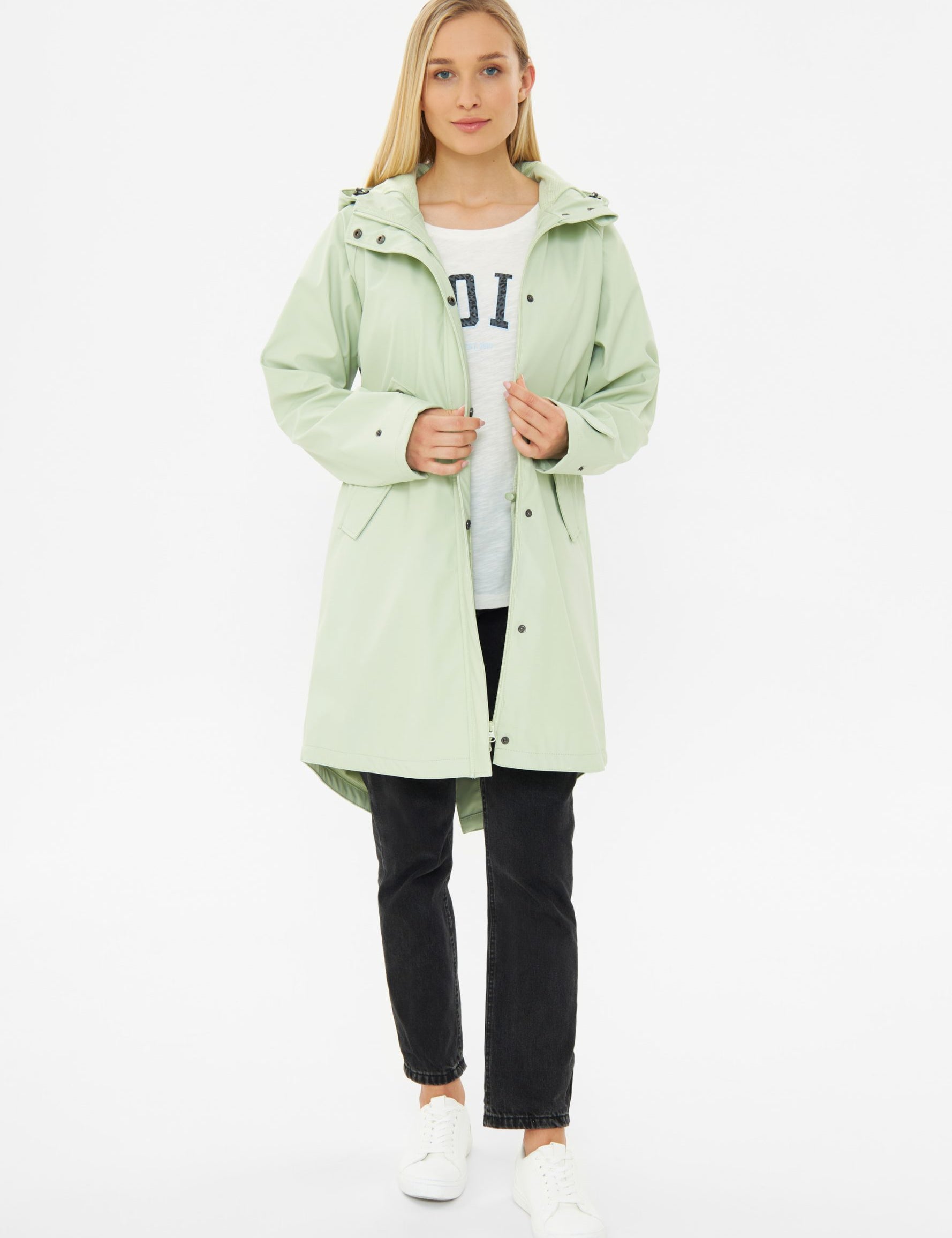 Frau in grüner Jacke und schwarzen Jeans