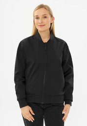 Frau in schwarzer Bomberjacke und Jeans.