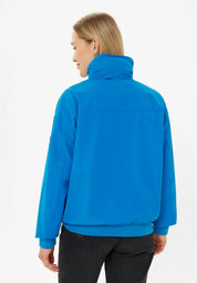Frau trägt blaue Outdoorjacke, Rückansicht.