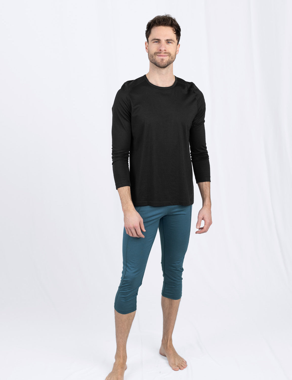 Mann in schwarzem Shirt und blauer Hose steht
