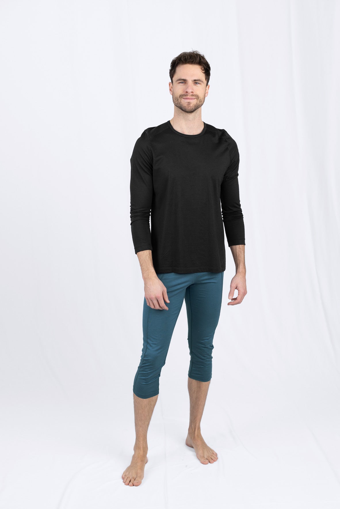 Mann in schwarzem Shirt und blauer Hose steht
