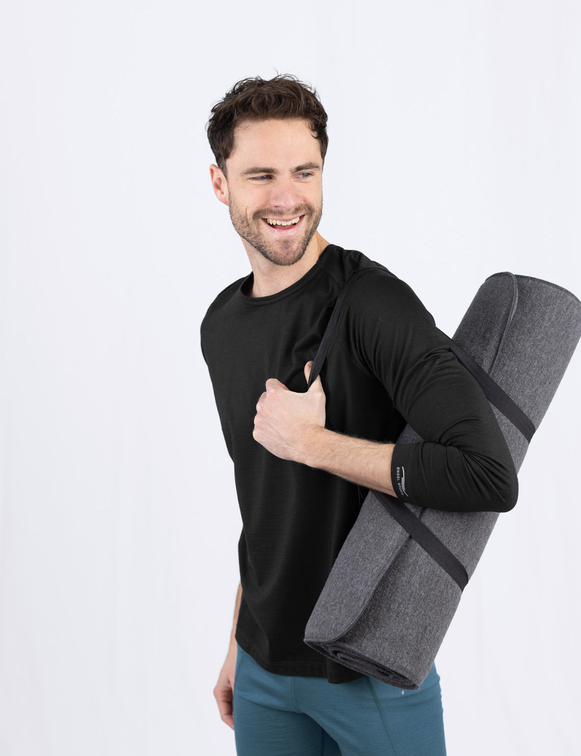 Lächelnder Mann mit Yogamatte und Daumen hoch