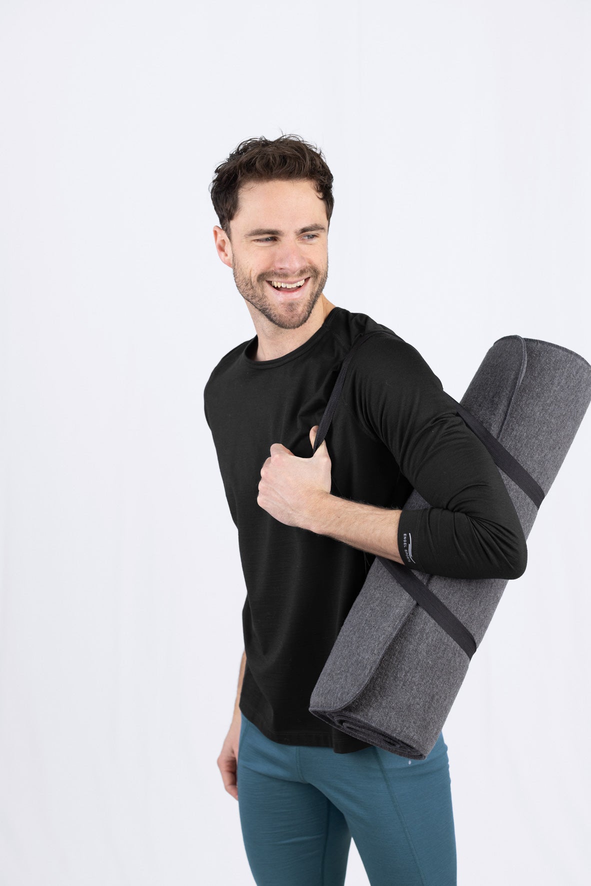 Lächelnder Mann mit Yogamatte und Daumen hoch