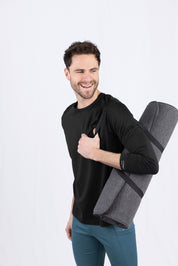 Lächelnder Mann mit Yogamatte und Daumen hoch