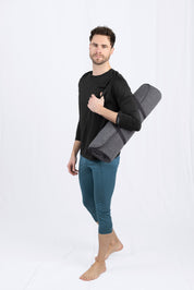 Mann mit Yogamatte posiert im Studio