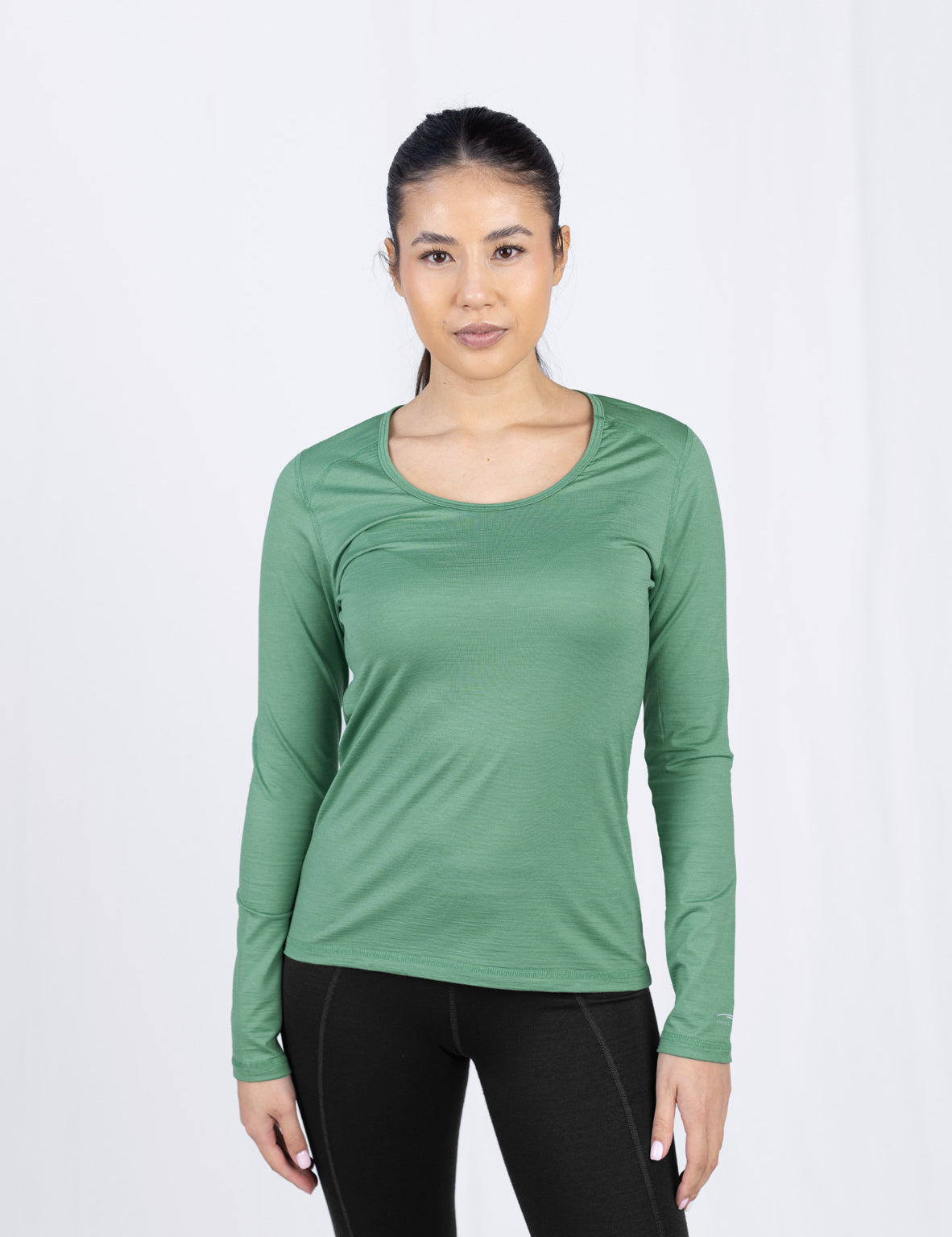 Frau in grünem Langarmshirt und schwarzer Hose