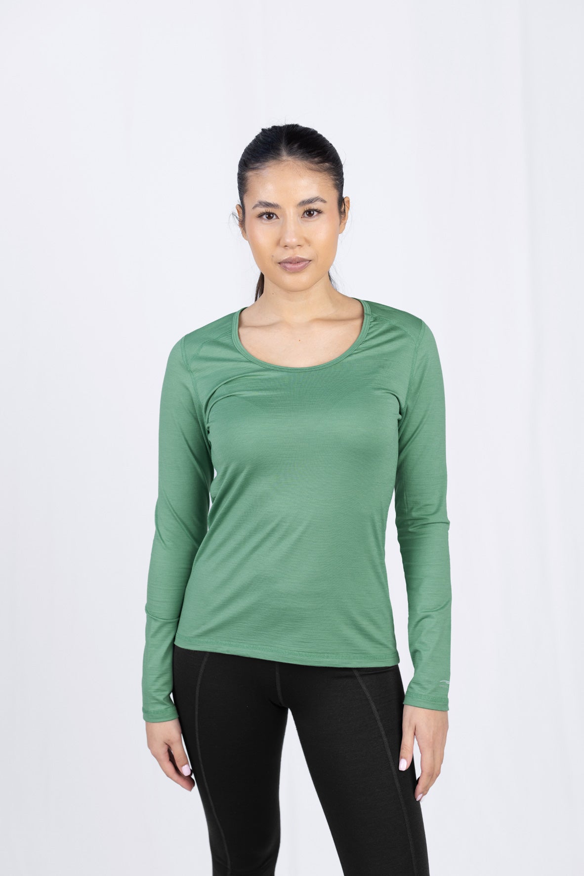 Frau in grünem Langarmshirt und schwarzer Hose