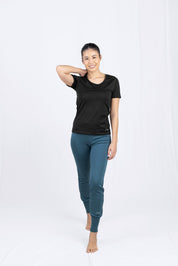 Frau in schwarzer Bluse und türkisen Leggings