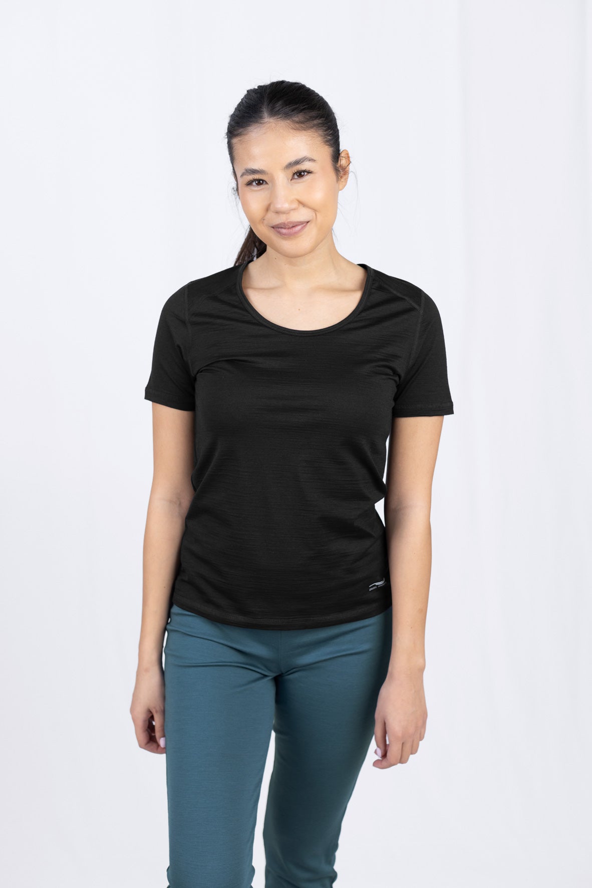 Frau in schwarzem T-Shirt und türkisfarbener Hose