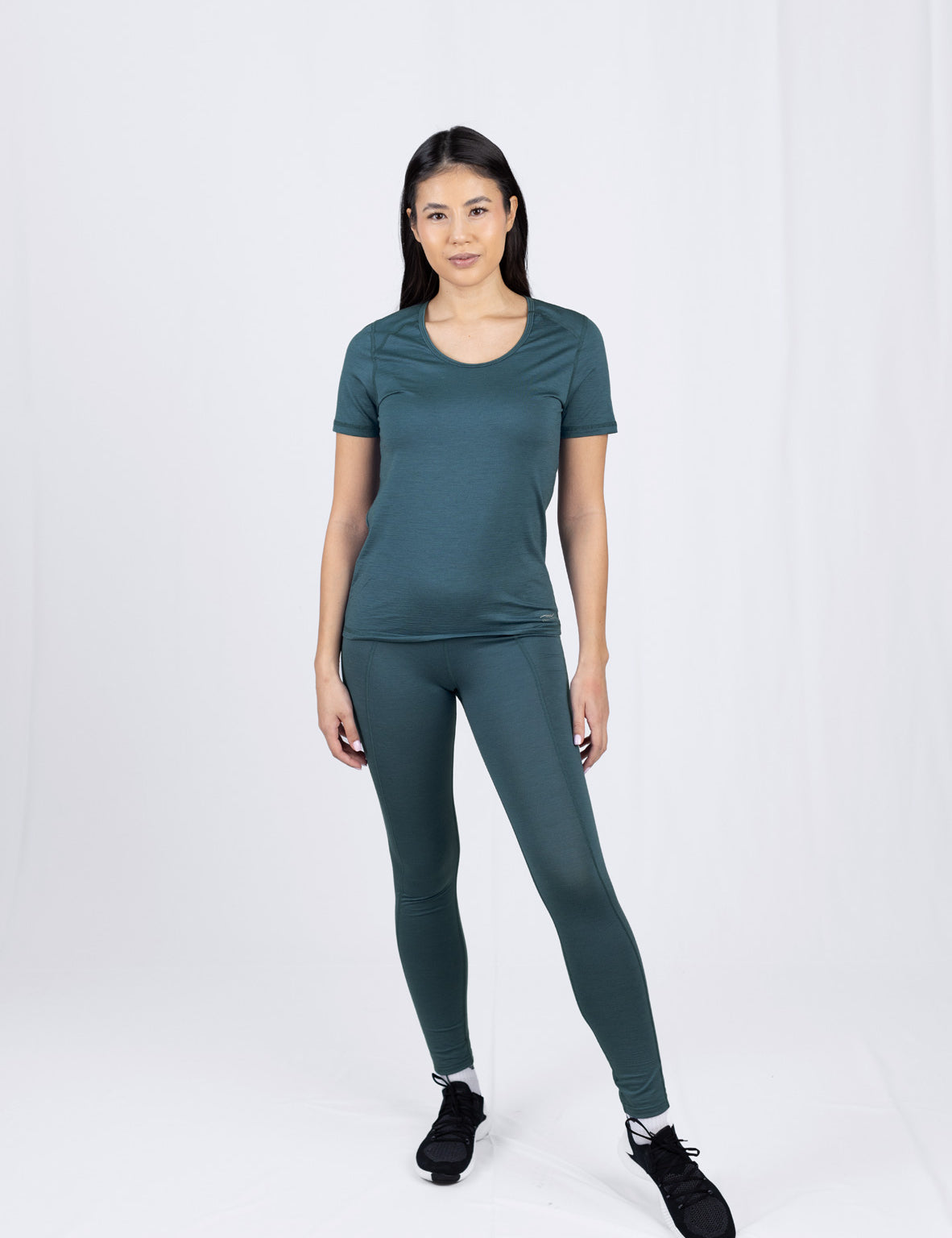 Frau in grünem Sportoutfit steht frontal