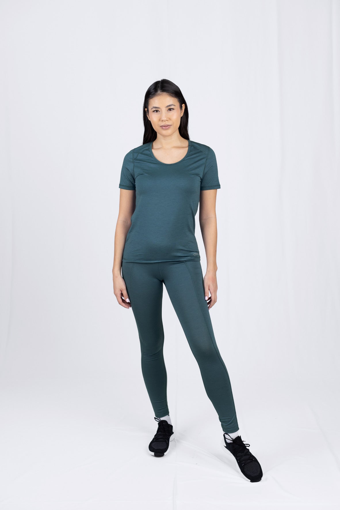 Frau in grünem Sportoutfit steht frontal