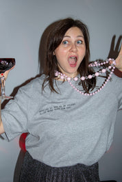 Überraschte Frau mit Wein und Perlenkette