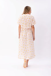 Frau in sommerlichem, gemustertem Kleid von hinten.