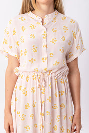 Frau trägt rosa Kleid mit gelben Blumenmustern.