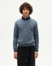 Junger Mann in blauem Pullover und schwarzer Hose