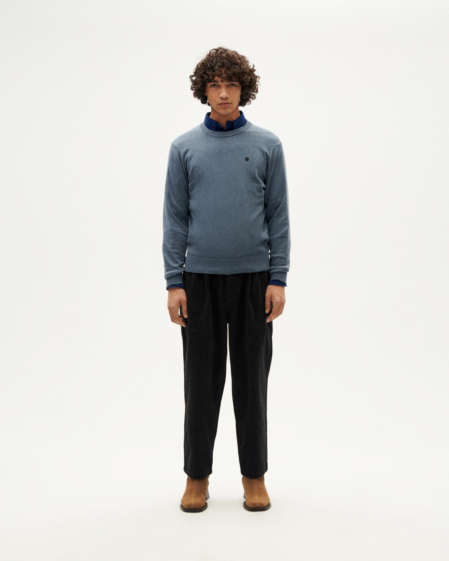 Mann in blauem Pullover und schwarzer Hose