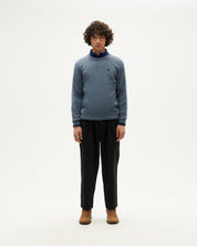 Mann in blauem Pullover und schwarzer Hose