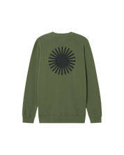 Grüner Pullover mit schwarzem Strahlenmuster auf dem Rücken.