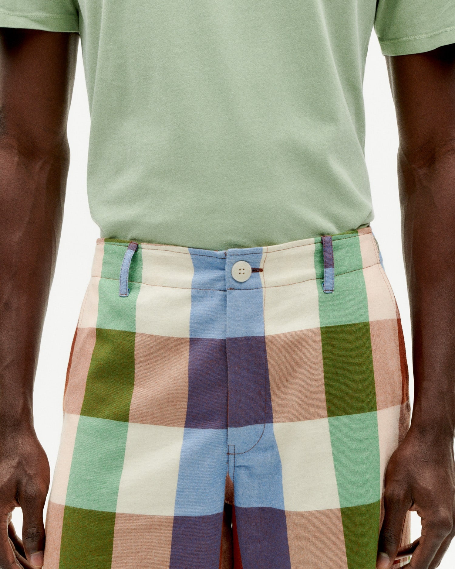 Mann in karierten Shorts und grünem Shirt.