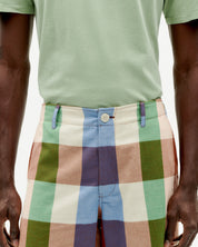 Mann in karierten Shorts und grünem Shirt.