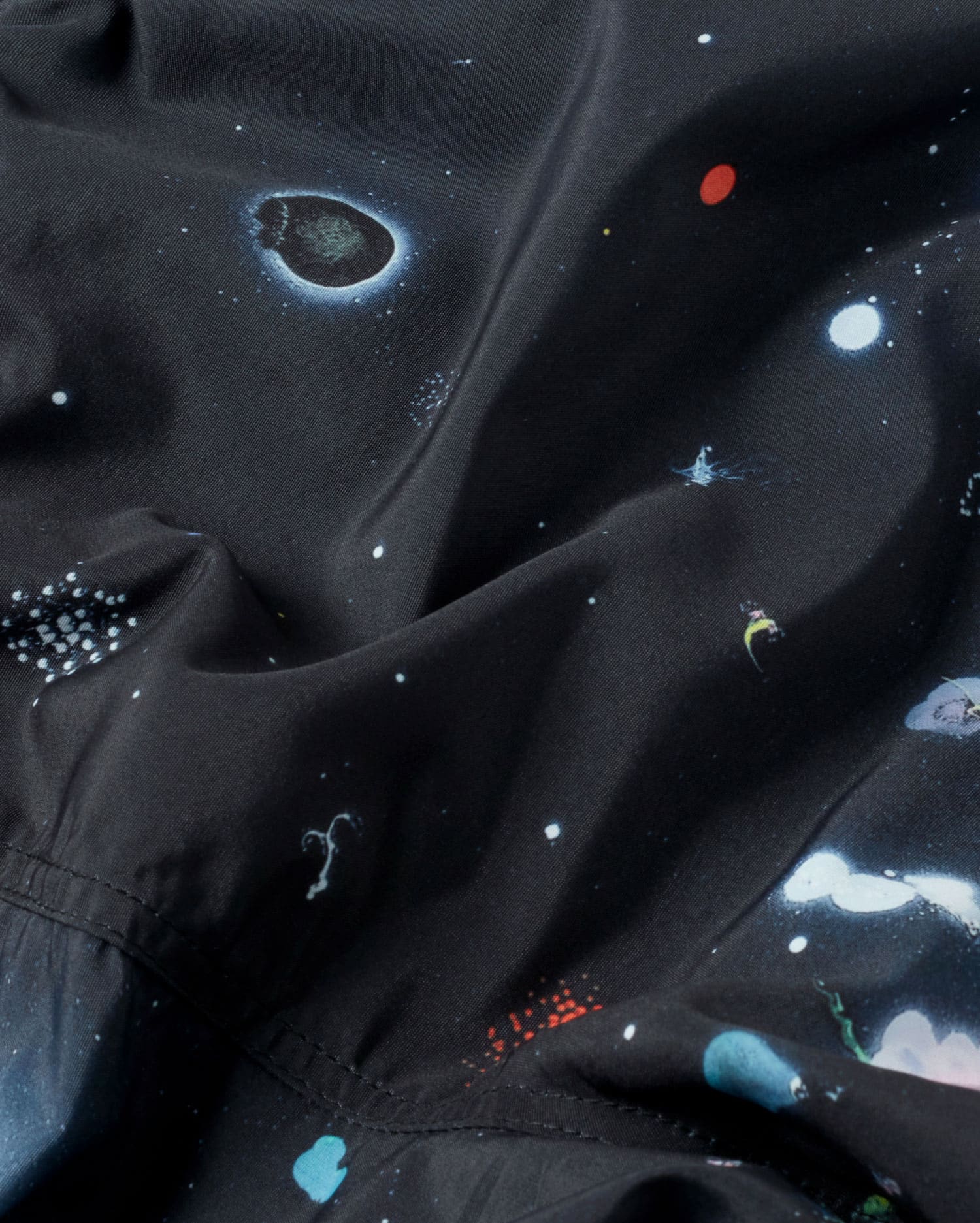 Stoff mit Weltraummuster und leuchtenden Planeten.