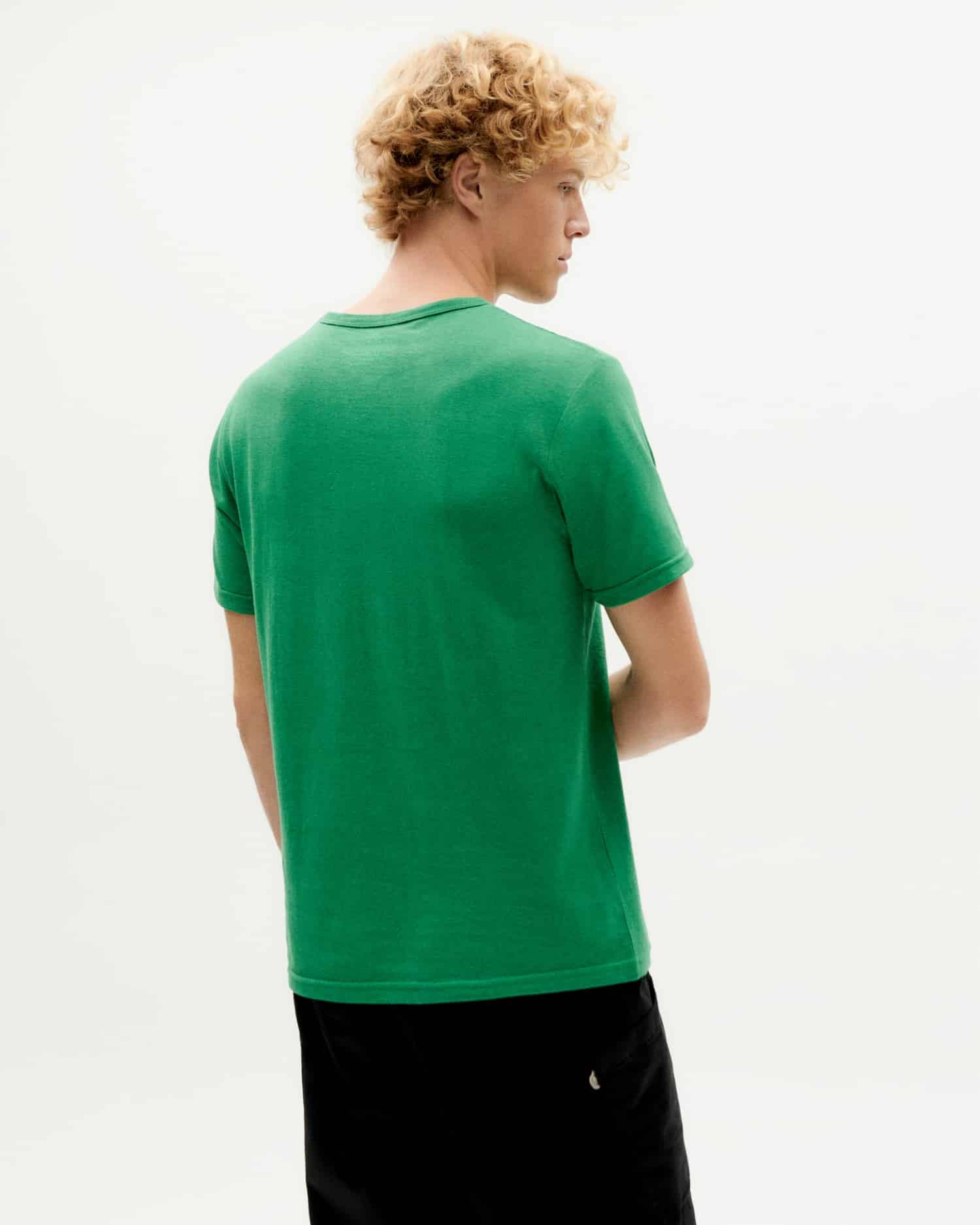 Mann mit lockigem Haar trägt grünes T-Shirt.