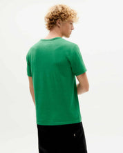 Mann mit lockigem Haar trägt grünes T-Shirt.