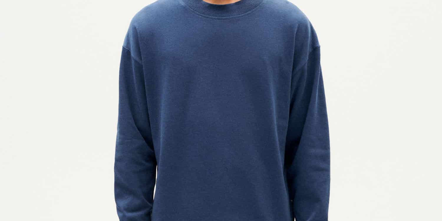 Junger Mann in blauem Pullover und brauner Hose