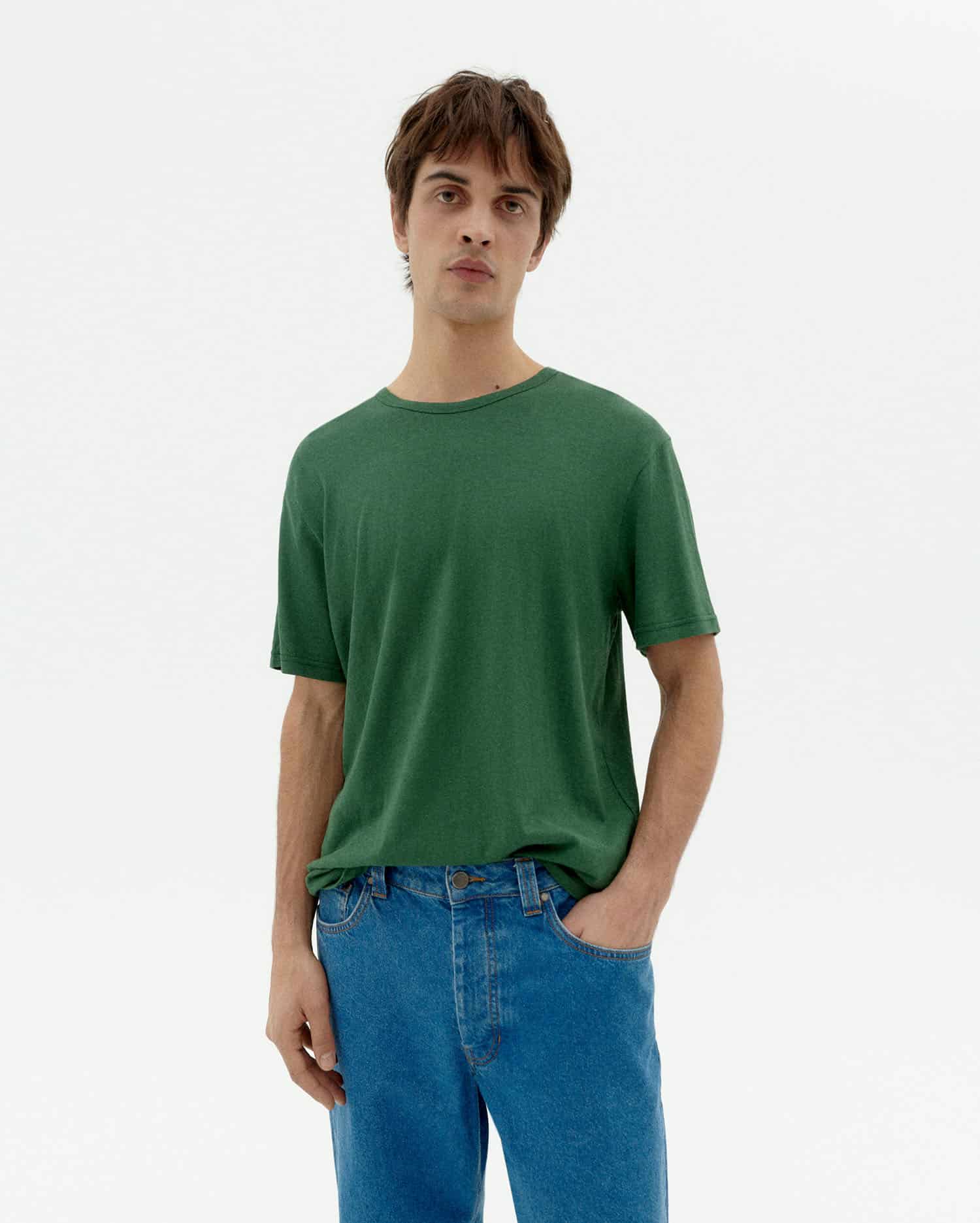 Mann in grünem T-Shirt und blauen Jeans