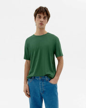 Mann in grünem T-Shirt und blauen Jeans