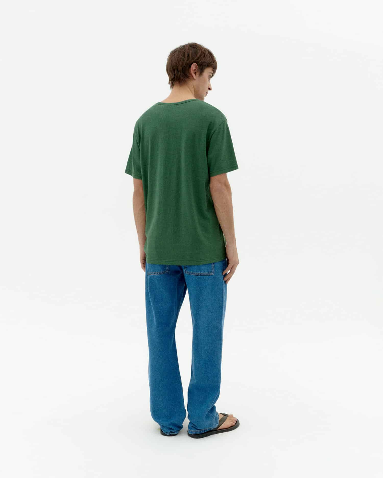 Mann von hinten in grünem T-Shirt und Jeans