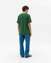 Mann von hinten in grünem T-Shirt und Jeans