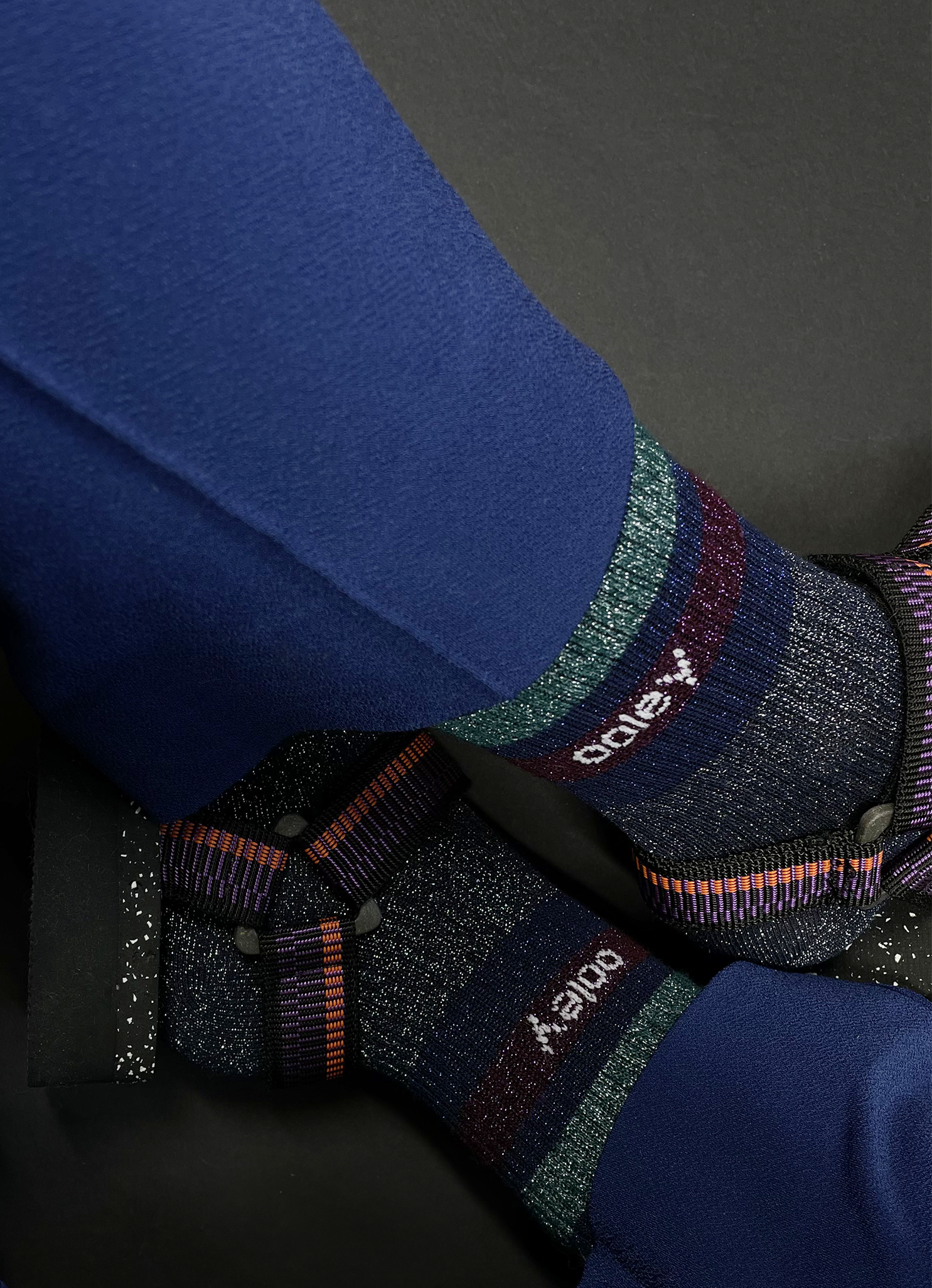 Blaue Socken mit buntem Glitzer auf dunklem Hintergrund