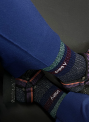 Blaue Socken mit buntem Glitzer auf dunklem Hintergrund