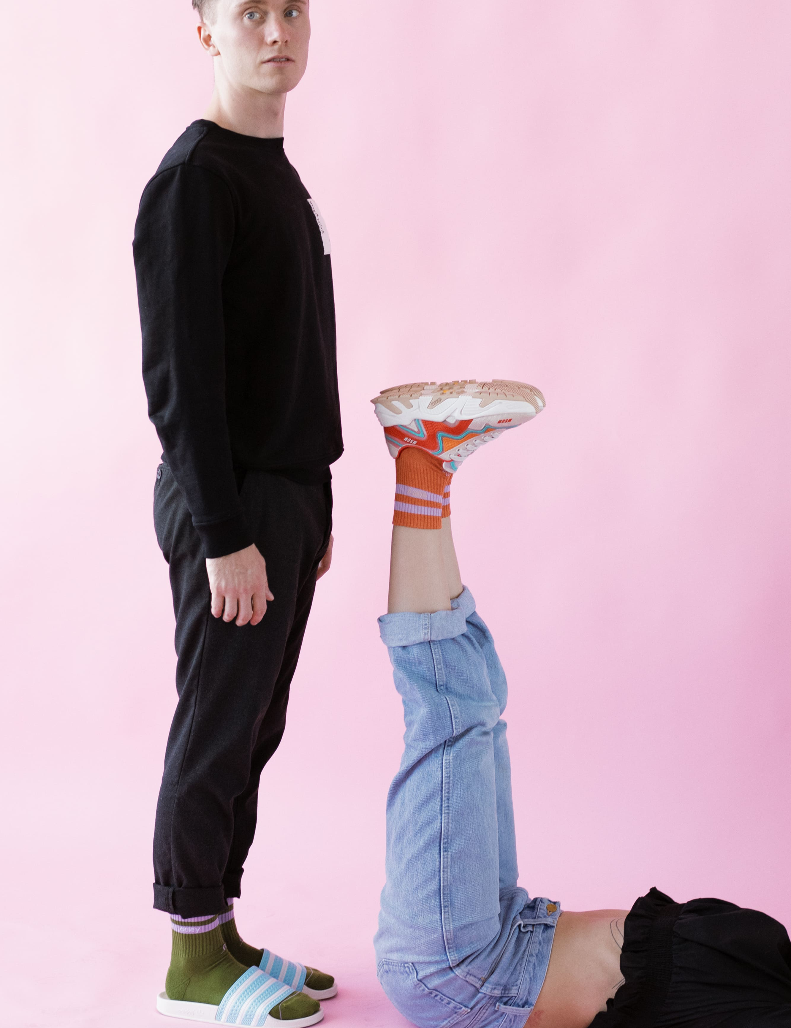 Mann steht neben umgedrehtem Bein mit Sneaker