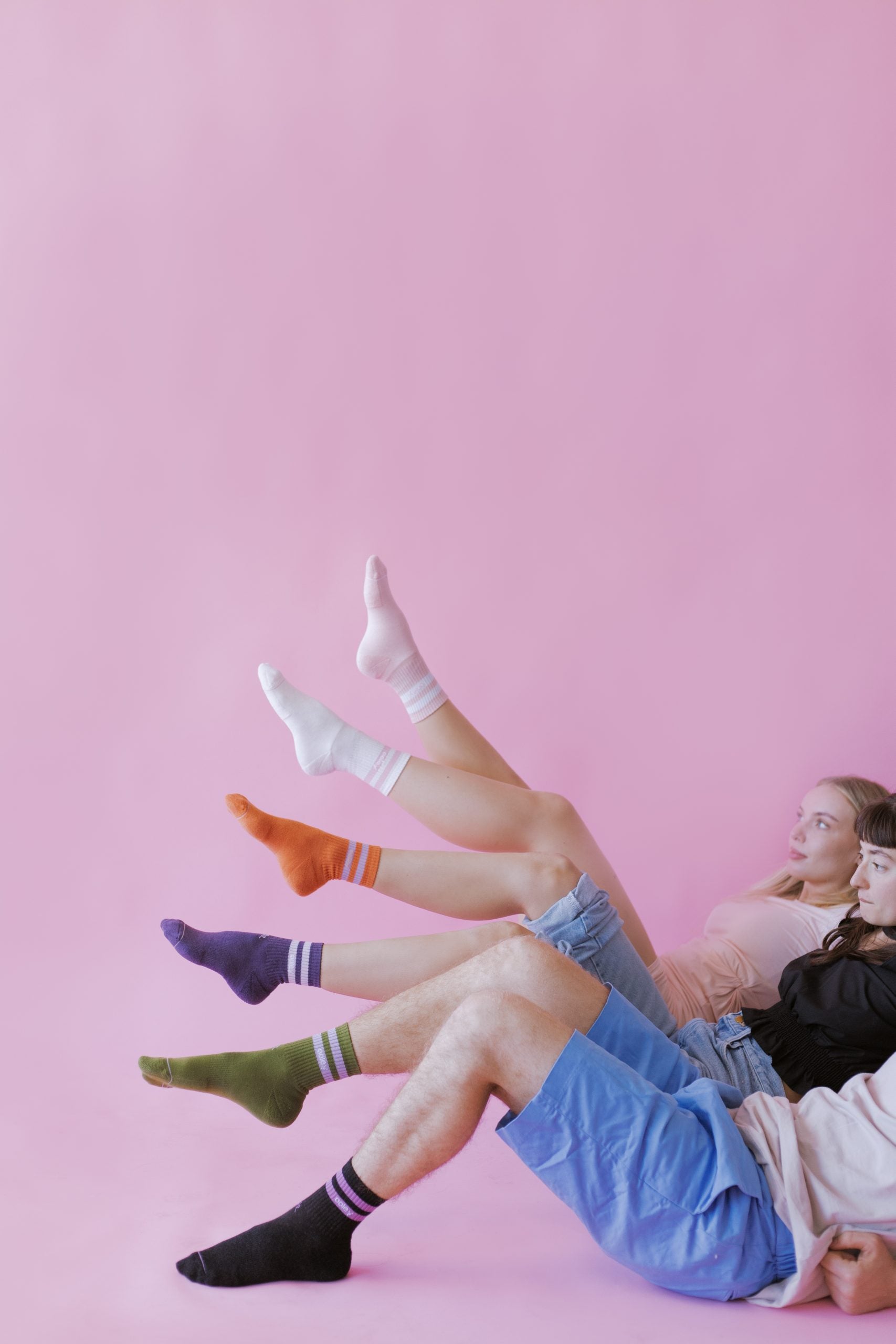 Jugendliche mit bunten Socken vor rosa Hintergrund