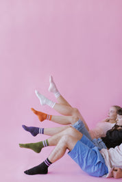 Jugendliche mit bunten Socken vor rosa Hintergrund