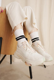 Zerrissene Hose und Sneakers an sitzender Person