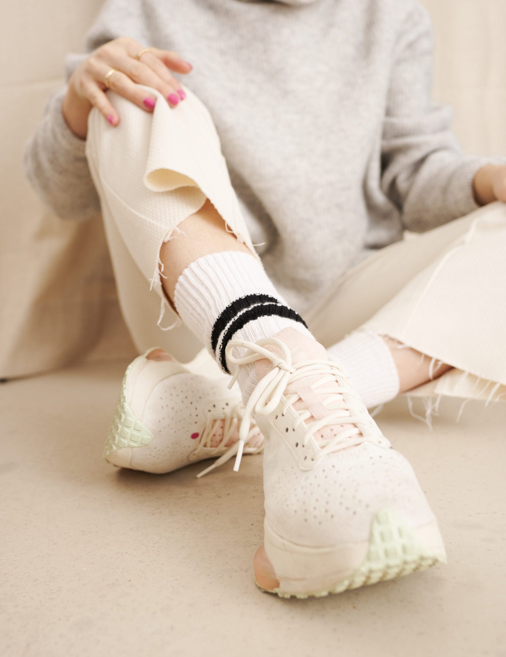 Frau in modischen Sneakers und zerrissener Jeans
