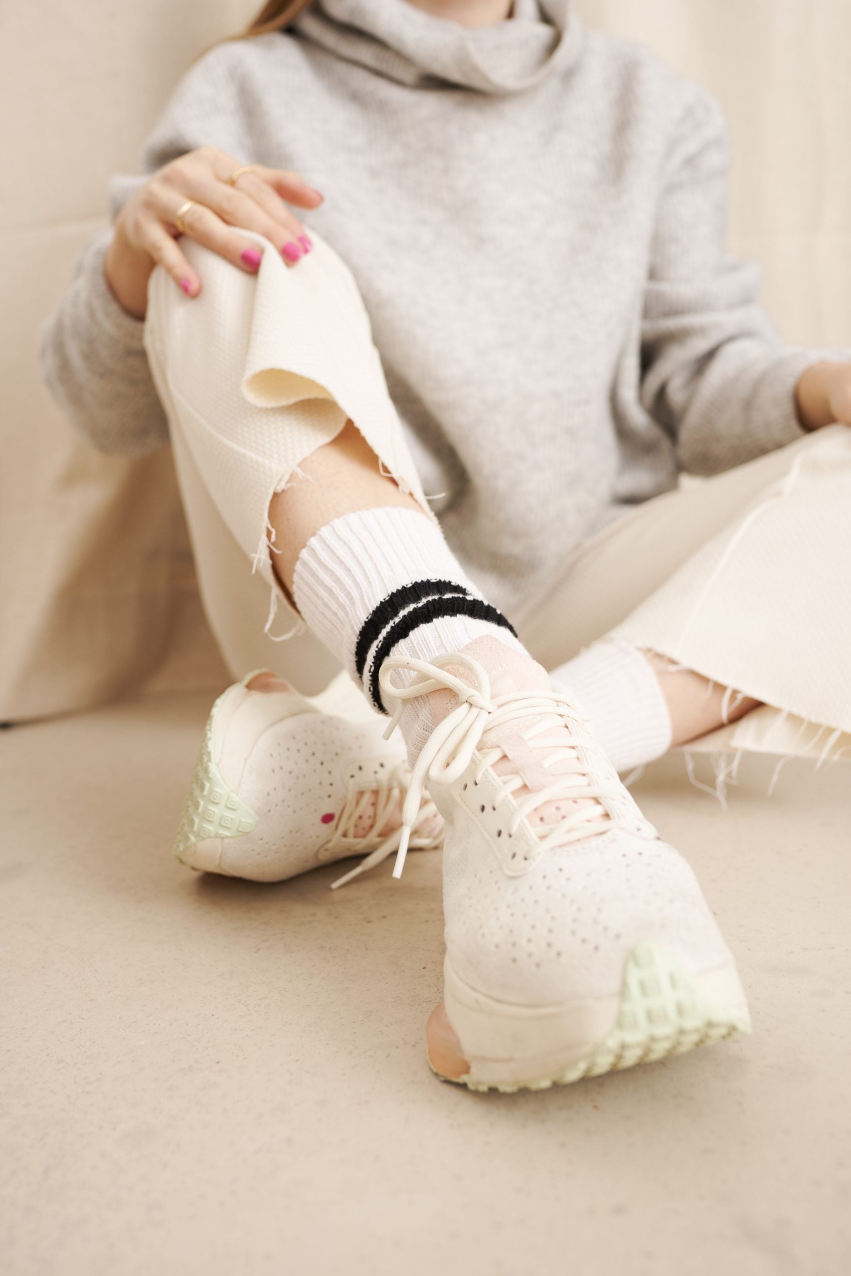 Frau in modischen Sneakers und zerrissener Jeans