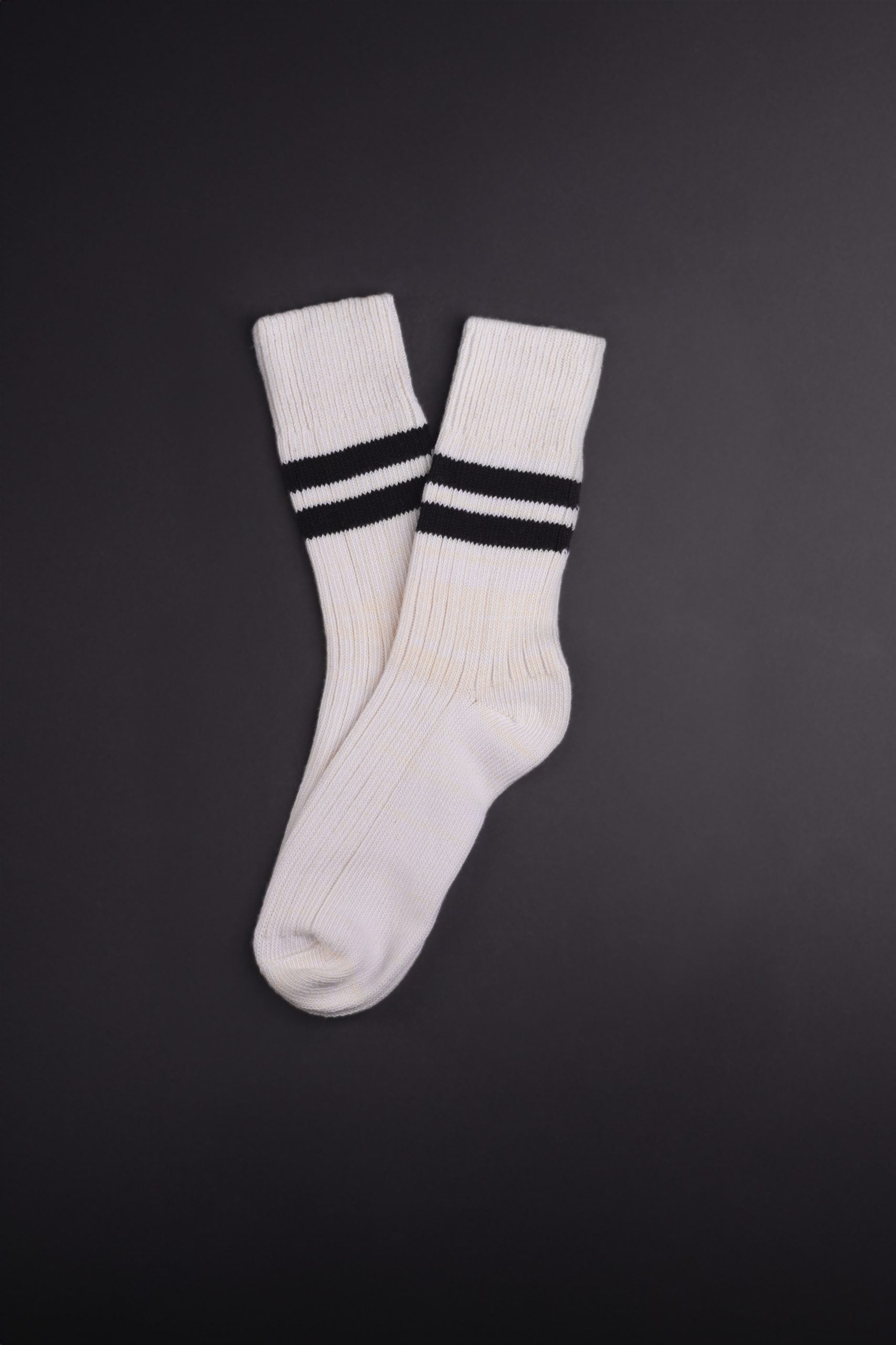 Weiße Socken mit schwarzen Streifen auf dunklem Hintergrund