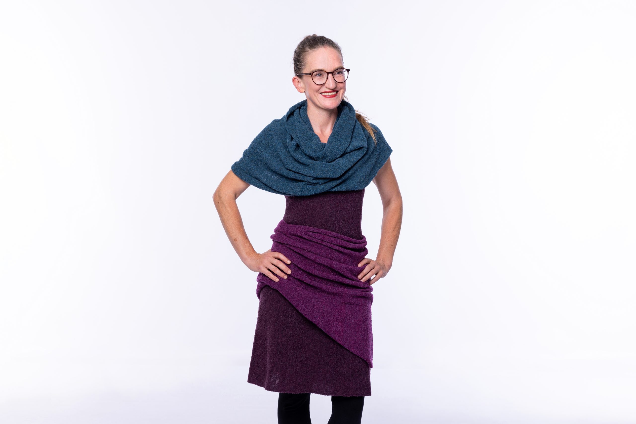 Frau in stilvollem Outfit mit Schal lächelt