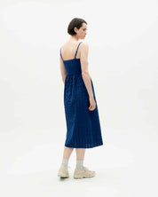 Frau in blauem Kleid von hinten betrachtet.