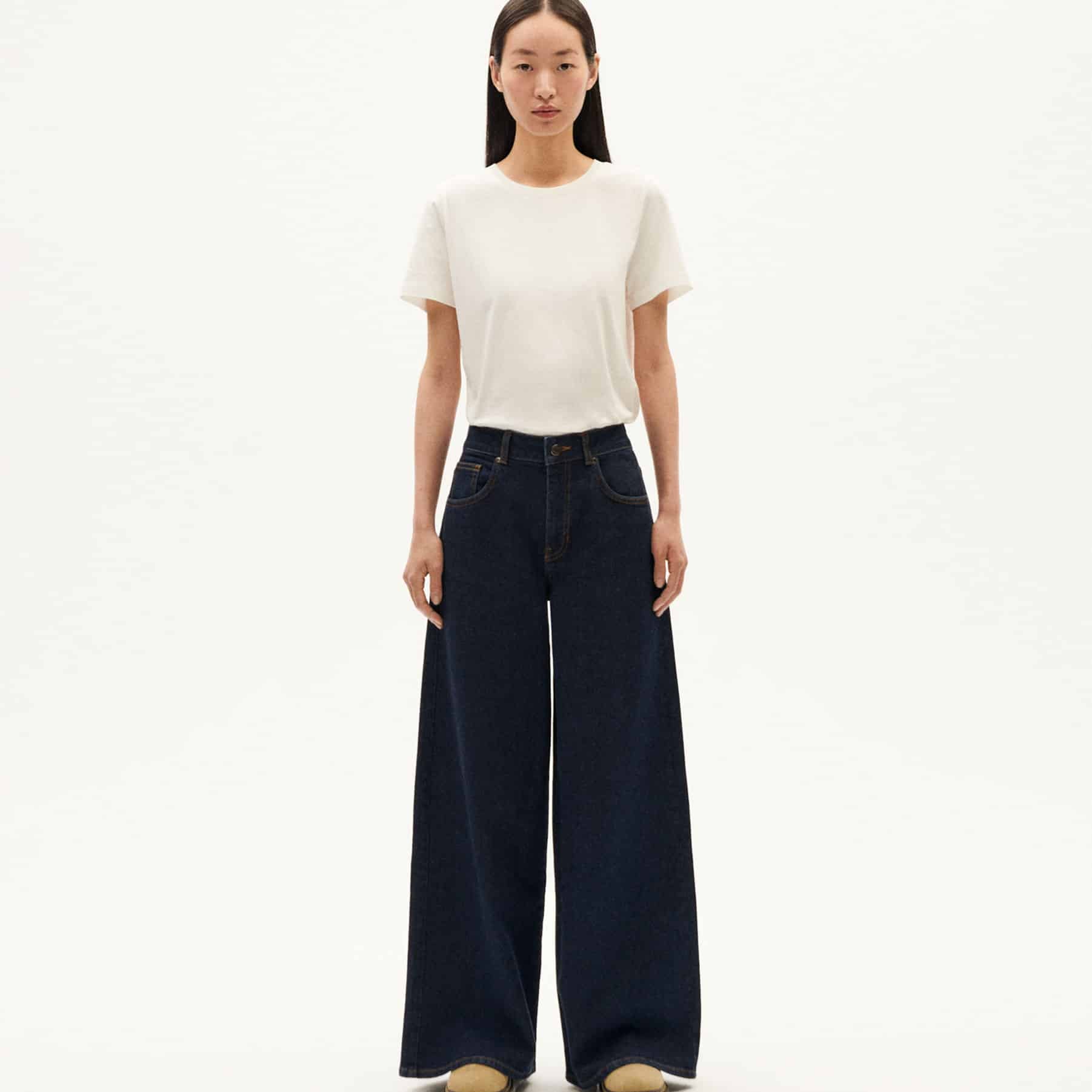 Frau in weißen Shirt und weiten Jeans