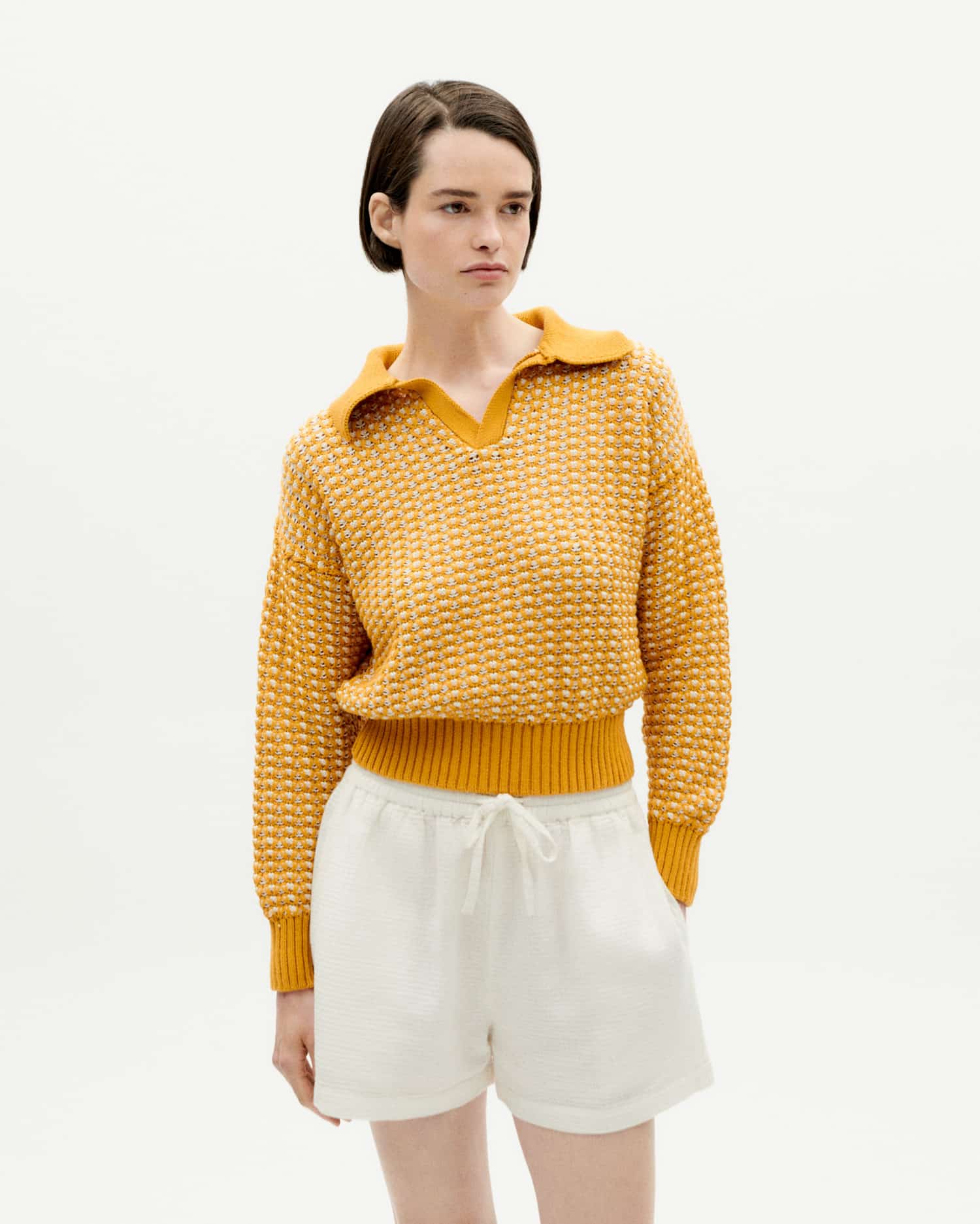 Frau in gelbem Pullover und weißen Shorts